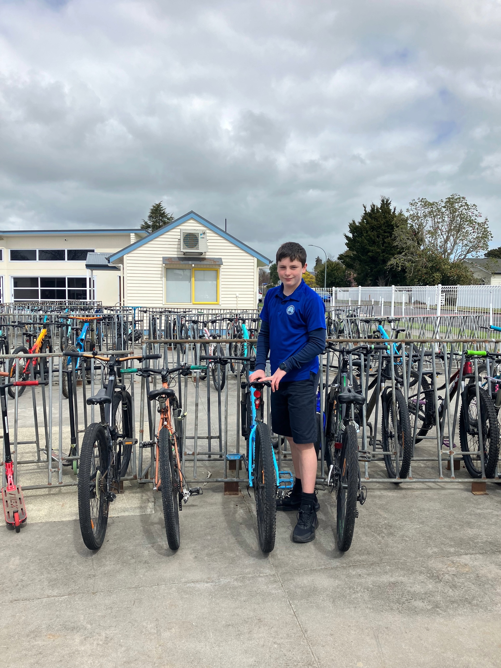Cambridge Middle School student, Jakob Robbers in front of the School's bike racks.