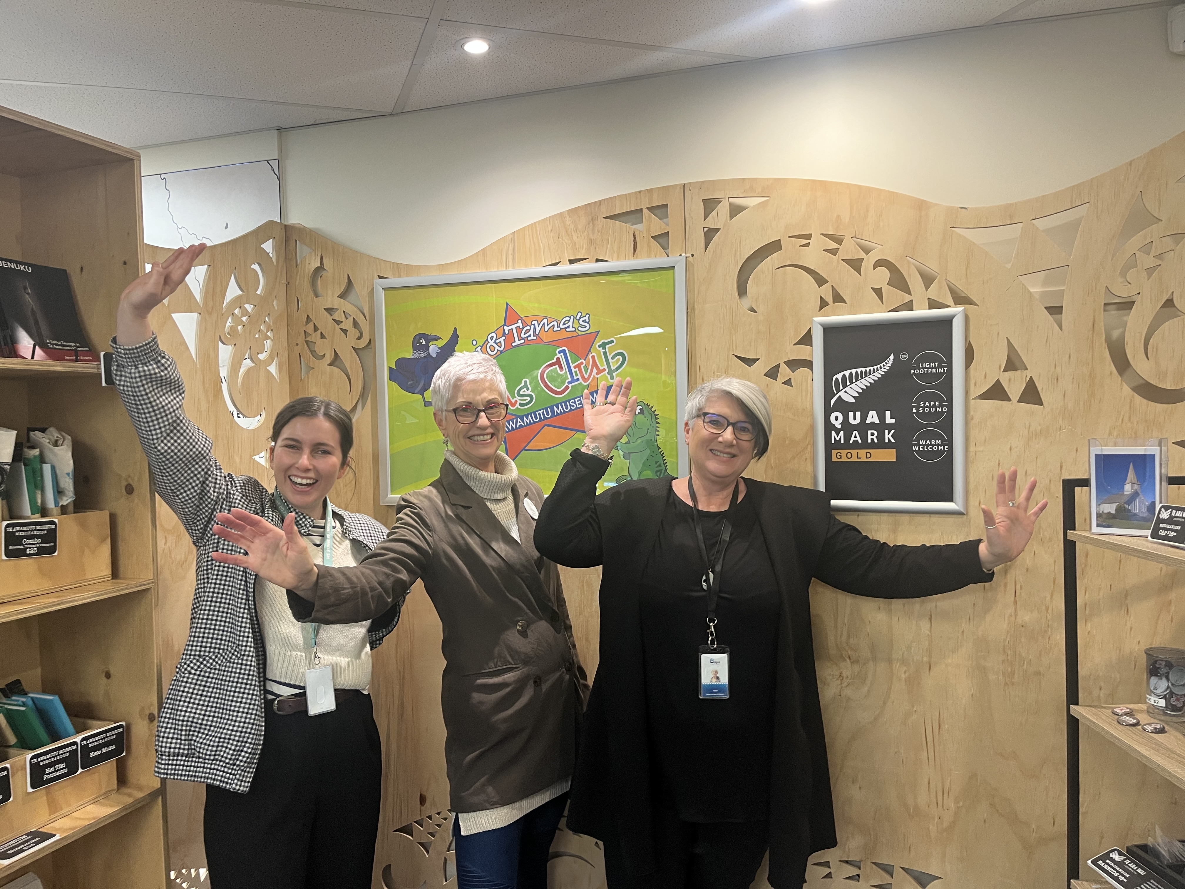 Photo of our Te Awamutu Museum employees in front of the Gold Qualmark award.